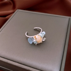 Detailed shot of an adjustable shell and pearl ring on a jewelry display box