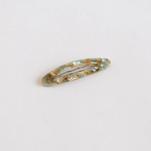 Détail d'une barrette à cheveux en acétate avec motif marbré et fermoir en métal argenté
