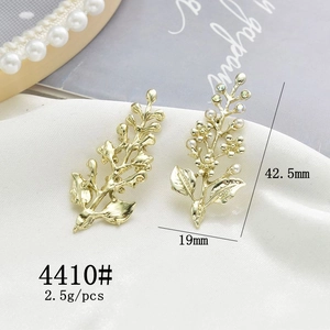 Detail of golden rose branch charms with white pearls and rhinestones for DIY jewelry