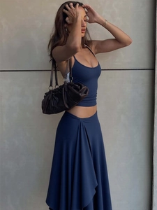 Women's chic dark blue two-piece set with a halter crop top and long irregular skirt