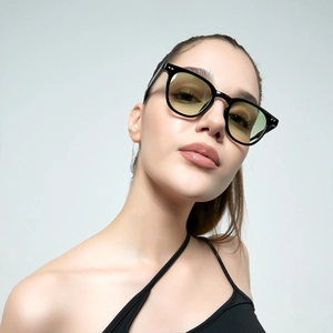 Classic round rivet sunglasses with black frame and yellow lenses worn by a model