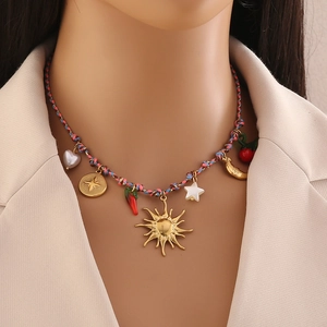 Collier tissé bohème avec breloques étoile de mer et soleil sur un blazer beige chic