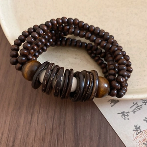 Macro shot of vintage coconut shell and dark brown wooden beaded multi-layer bracelet