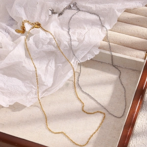 Detailed macro view of 1.4mm gold and silver stainless steel cross chains on elegant display