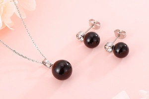 Detailed shot of pearl pendant necklace and stud earrings set with crystal accents
