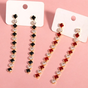 Detail of colorful tassel earrings with square-cut cubic zirconia in gold settings