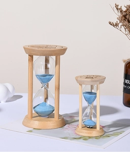 Detail of wooden hourglass set with blue sand and 2017 engraved pattern on the top