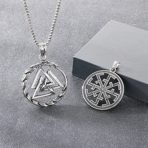 Viking Valknut and Kolovrat pendants in antique silver finish on a textured background