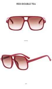 Detail view of red double-bridge pilot sunglasses with tea gradient lenses and metal rivets