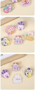Macro detail of acrylic cat brooches with positive Chinese blessings and safety pin