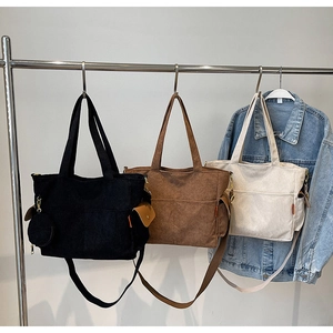 Three corduroy tote bags in black brown and beige hanging to show texture and capacity