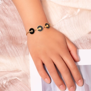 Dettaglio del bracciale in acciaio al titanio oro con smalto nero su seta rosa