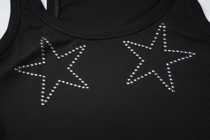 Detail of black ribbed knit vest featuring two silver studded star patterns on the chest