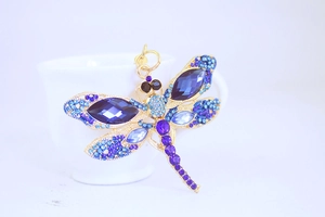 Macro shot of dragonfly keychain with colorful rhinestones and gold metal base
