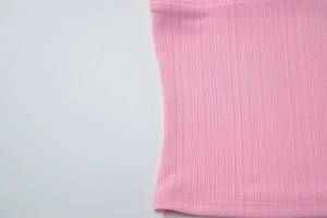 Dettaglio ravvicinato del tessuto a coste rosa con cucitura dell'orlo professionale