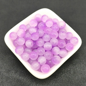 Close-up of 8mm purple gradient glass beads for DIY jewelry making in a white bowl