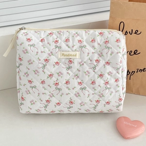 Macro detail of the quilted floral toiletry bag featuring pink roses and bow patterns