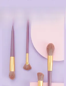 Detail of purple makeup brush set with golden ferrules and soft gradient bristles