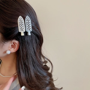 Detail of elegant zircon leaf hair clips worn by a model to show decorative styling