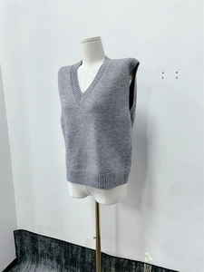 Close-up of the grey V-neck knitted sweater vest showing detailed yarn weaving texture