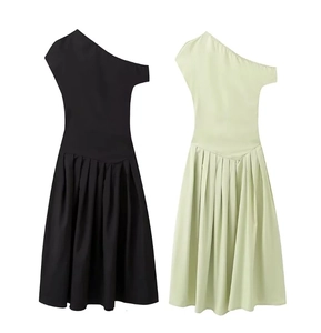 Detalle de vestidos plisados de un hombro en negro y verde menta con cintura entallada