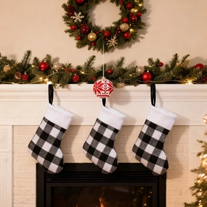 Three buffalo plaid Christmas stockings with white faux fur cuffs hanging on a white fireplace