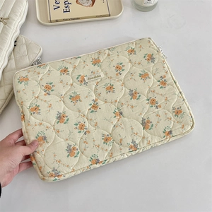 Detailed close-up of floral quilted laptop sleeve with soft cotton texture and embroidery