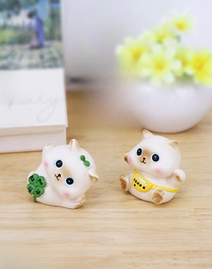 Cute miniature cat figures with lucky clover and fortune bag on a wooden desk