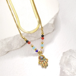 Detail of gold layered necklace featuring a Hamsa Hand pendant with Evil Eye and beads