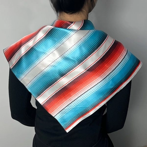Detail view of the striped silk satin scarf worn by a model against a grey background