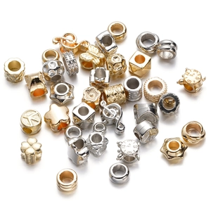 Detailed macro view of assorted gold and silver CCB plastic spacers for DIY jewelry making