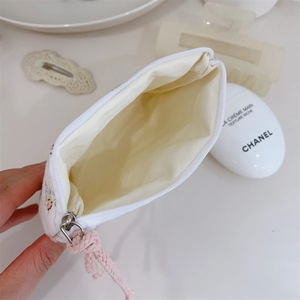 Vue intérieure de la pochette matelassée à fleurs avec fermeture éclair blanche