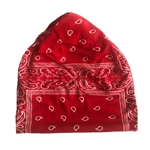 Detail shot of the soft red knit beanie featuring a classic white paisley pattern