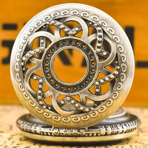 Macro detail of retro hollow-out floral pattern on the metallic pocket watch cover