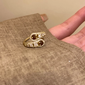 Detailed macro view of a vintage gold bypass ring featuring two round tiger eye stones