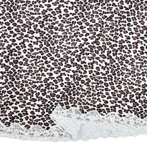 Vue macro du tissu à imprimé léopard avec une bordure en dentelle blanche délicate
