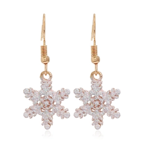 Macro detail of gold-tone snowflake earrings with sparkling pink and white glitter