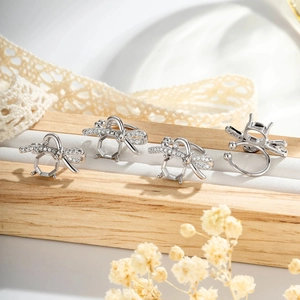 Silver bee insect ear clips with sparkling zircon wings on a professional wood display