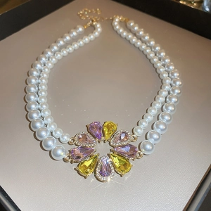 Macro view of double-layer pearl necklace with colorful crystal floral pendant in gift box