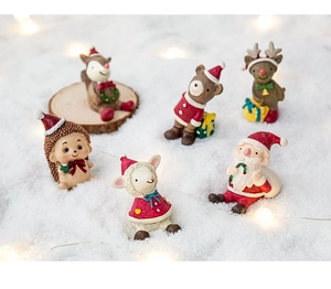 Miniature resin Christmas figurines featuring Santa and forest animals in warm snow scene