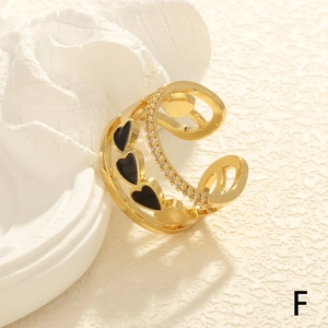 Detail of gold layered open ring with black enamel heart and pave zircon accents