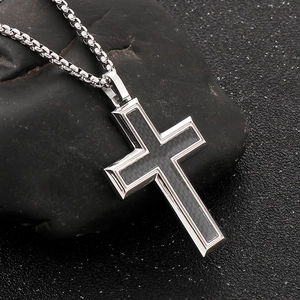 Detailed close-up of a carbon fiber inlaid cross pendant on a stainless steel box chain