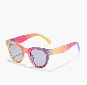 Detail of glitter round frame kids sunglasses with rainbow gradient and shimmer finish