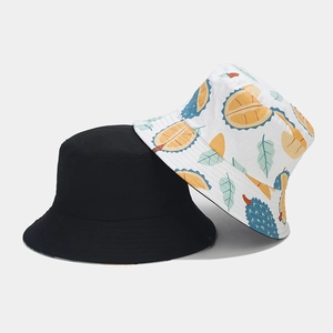 Detail of reversible bucket hat featuring creative tropical durian patterns on white canvas