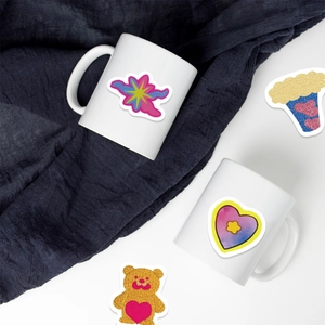 Cute cartoon graffiti stickers applied to white ceramic mugs for personalized DIY decoration