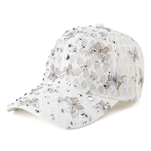 Close-up of white lace baseball cap featuring silver rhinestones and butterfly patterns