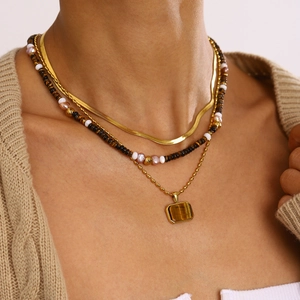 Layered gold snake chain with pearl beads and a tiger eye stone pendant necklace
