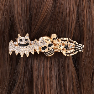 Halloween gold bat and skull hair clip with rhinestones worn on brown hair