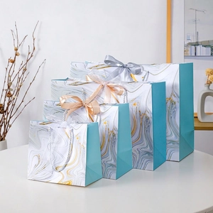 Elegant marble pattern gift bags in four sizes with ribbon bows and blue side accents
