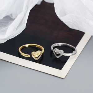 Close-up of gold and silver S925 heart rings with sparkling cubic zirconia stones